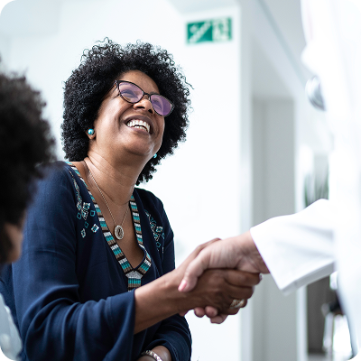Dentist warmly shaking hands with a smiling patient during a dental consultation, creating a welcoming and comfortable experience at the dental office.