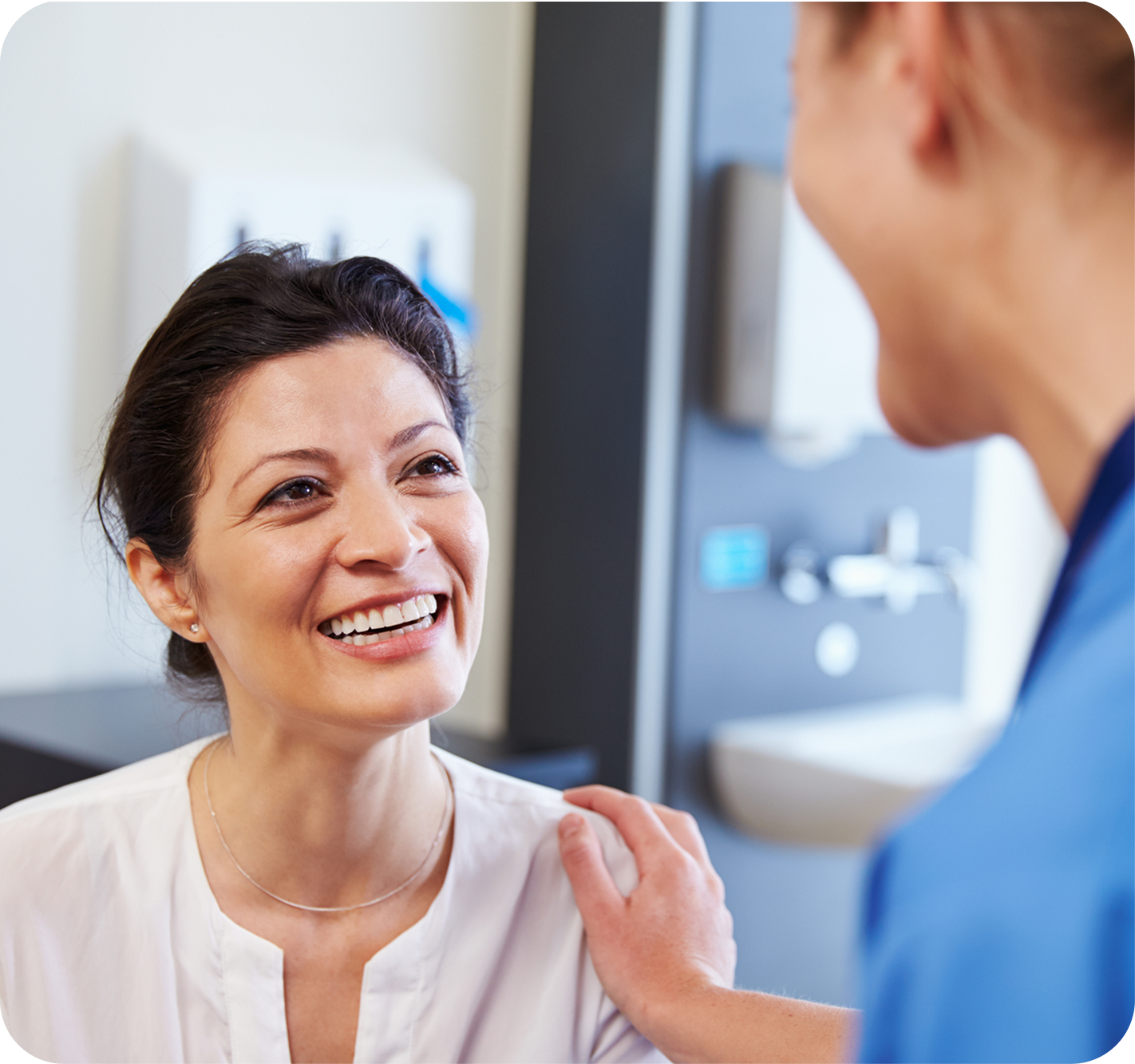 Smiling patient speaking with an oral surgeon during a dental consultation.