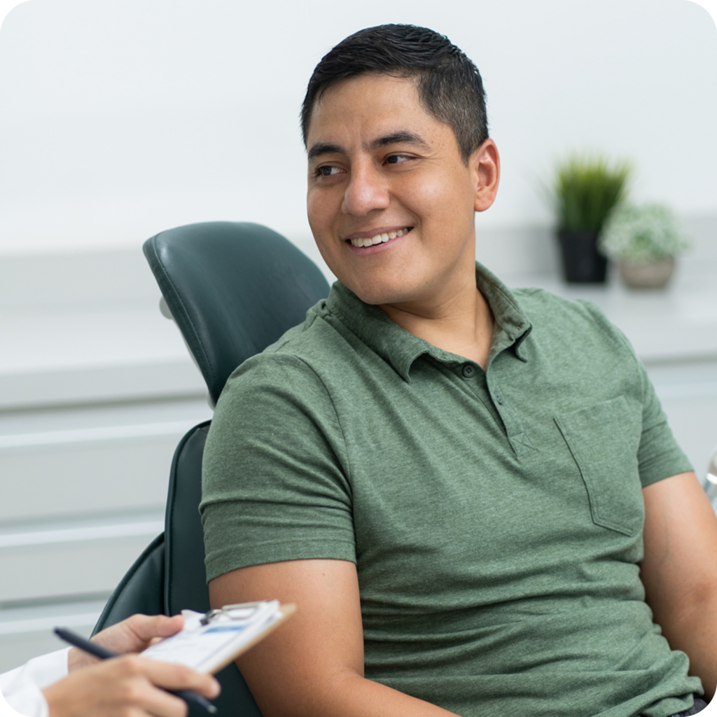 Patient consulting with a provider in a dental treatment room.